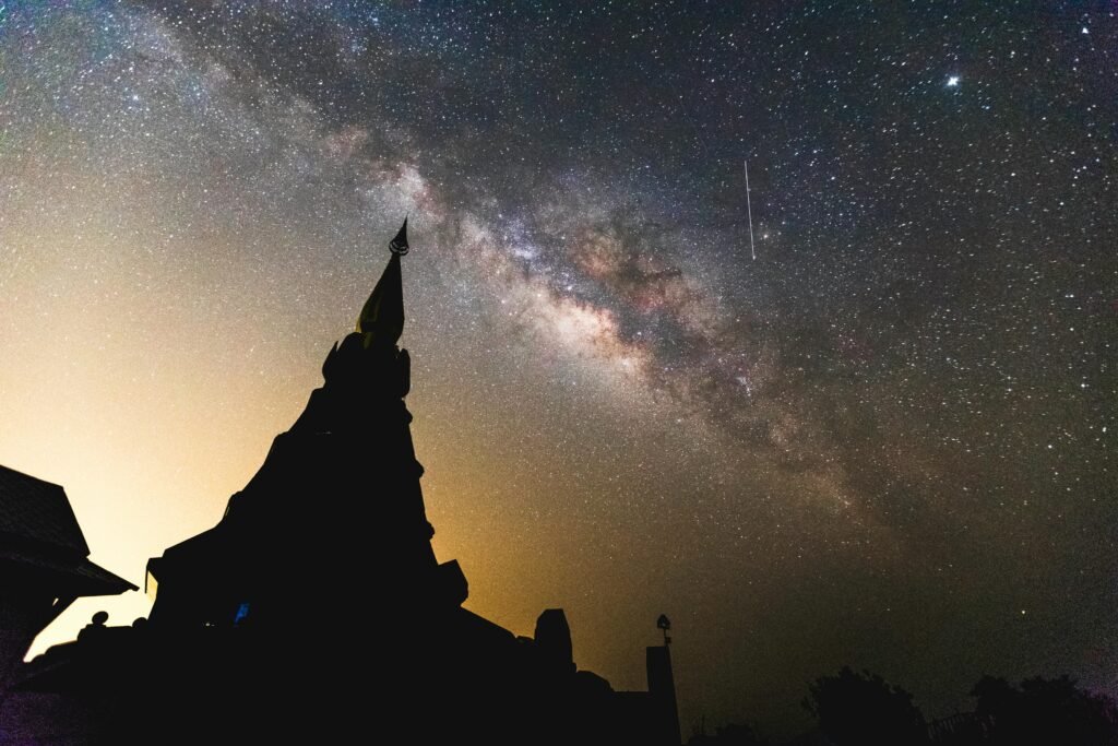 Stunning view of the Milky Way over a temple silhouette in Chiang Mai, Thailand.